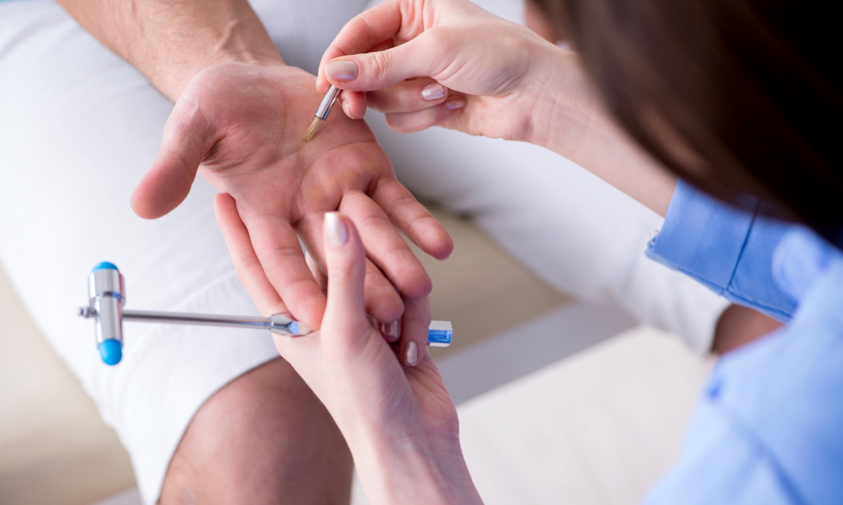 a doctor checking the hand reflexes of a patient