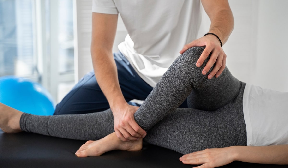 Therapist helping a woman stretch her leg and knee to improve mobility