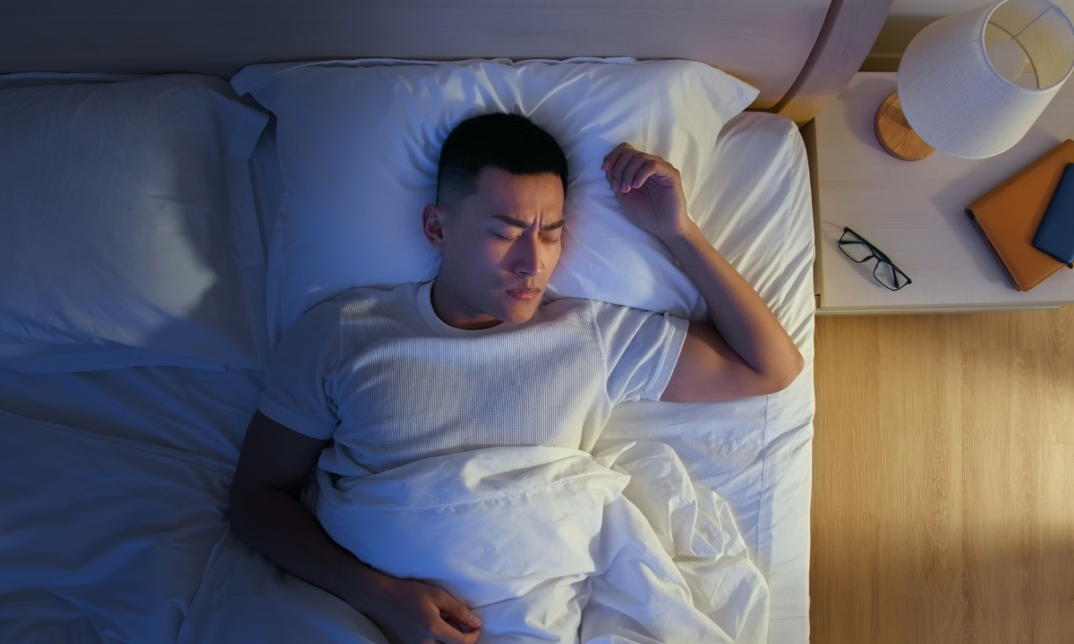 a man sleeping with a pained expression on his face