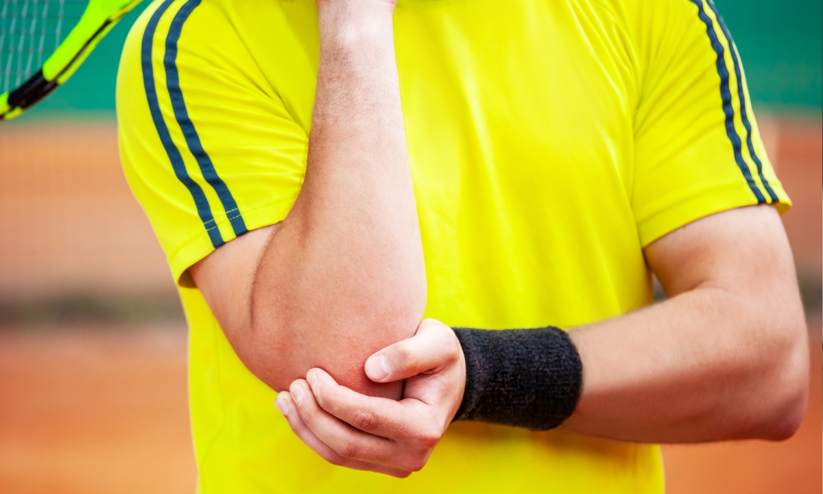 a person holding their elbow and a tennis racket