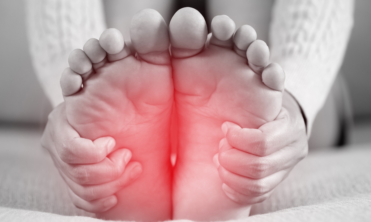 a black and white photo of feet with a red opaque circle around the arches